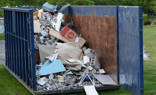 Commercial skip being loaded with waste at a West Ham business site